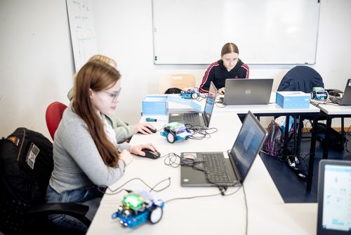 Schülerin beim Programmieren eines Roboters